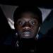 Ypsilanti resident Ndongo Ndaw uses his phone and listens to music while waiting in line for Black Friday on Wednesday night. Daniel Brenner I AnnArbor.com